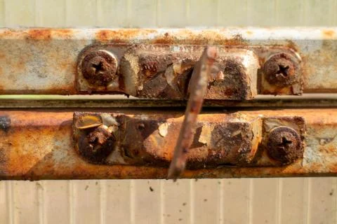 Old rusty window latch on a weathered greenhouse frame structure detail Stock Photos