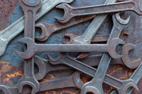 Old rusty wrench over battered metal table rough style. Wrenches top view for Stock Photos