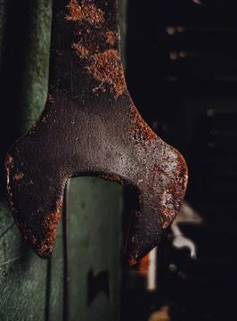 Old rusty wrench spanner tool hanging in a workshop, close up. Fotos Stock