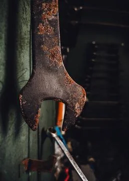 Old rusty wrench spanner tool hanging in abandoned workshop, close up. Fotos de archivo