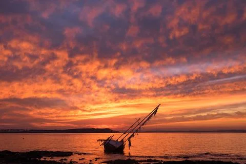 Old sailboat stranded in front of Gorriti Island, during sunset Stock Photos