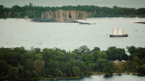 An old sailing ship sailing among the islands in cloudy weather Stock Footage 119271676
