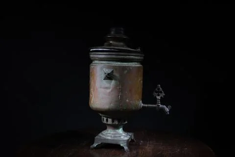 Old samovar on the table on black background Stock Photos