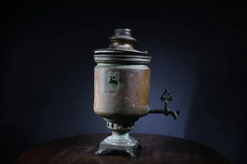 Old samovar on the table on black background Stock Photos