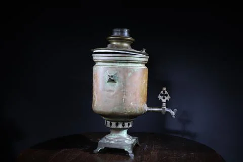 Old samovar on the table on black background Stock Photos
