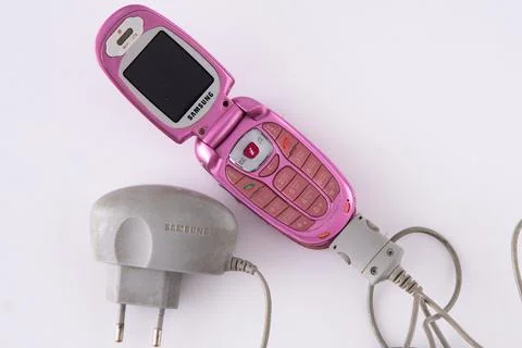 Old Samsung push-button flip phone. Pink color with charger. Foto stock