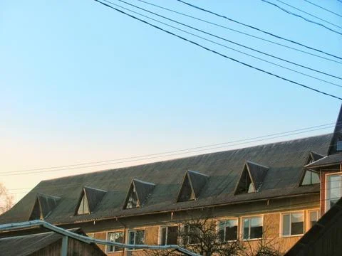 Old sanatorium building behind pine trees under sunny blue sky Stock Photos
