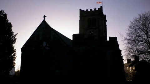 Old sandstone church in shadow illuminated from behind by sunset light. Stock Footage 87113053