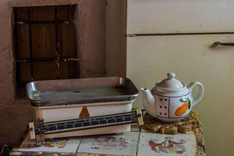Old scale and a teapot on a table in a house Stock Photos