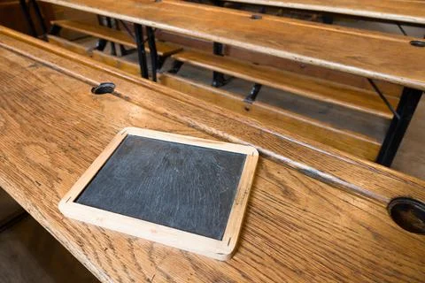 Old school classroom with slate tablet and wooden benches, UK Stock Photos