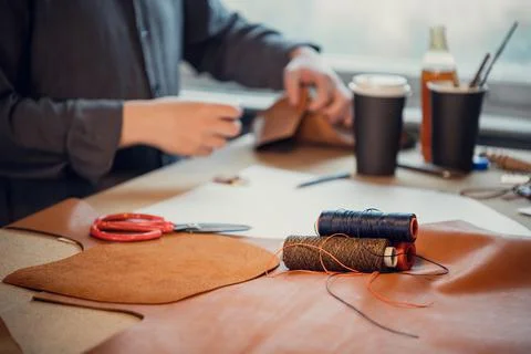 Old school workshop of an exclusive shoemaker. Spools of thread on the workbench Stock Photos