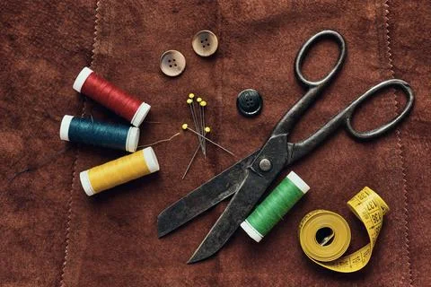 Old scissors and sewing objects on a natural suede background, top view Stock Photos
