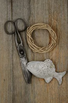 Old scissors, glasses, fish and hank of packthread over wooden background Stock Photos