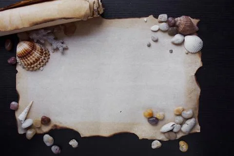 Old scroll of parchment with sea pebbles and seashells Stock-Fotos