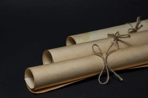 Old scrolls lie on a black background. Education concept.  Stock Photos