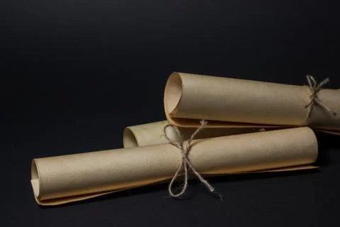 Old scrolls lie on top of each other on a black background.  Stock Photos