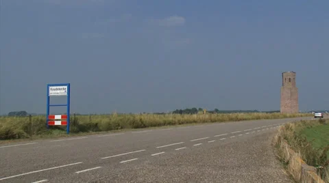 Old sea dike along the Eastern Scheldt estuary + medieval tower Plompe Toren Stock Footage 33160270