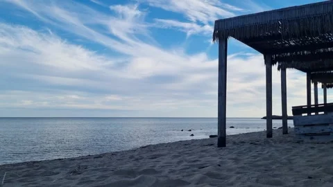 Old seaside pier over calm blue water under cloudy sky Stock Footage 320599425