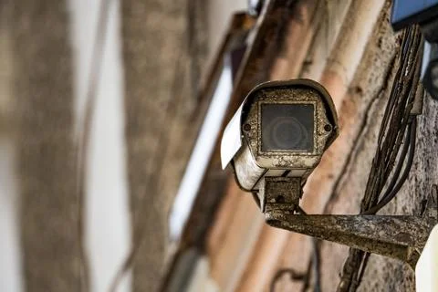 Old Security Camera Mounted on Weathered Wall Stock Photos
