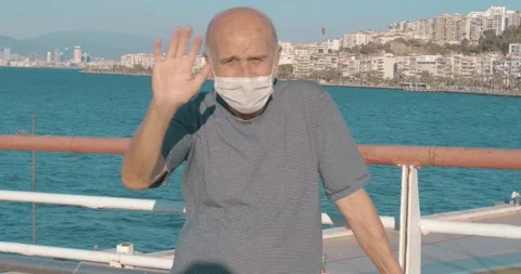Old senior 70+ man using face mask for protecting himself from virus and wave Stock Footage 141338618