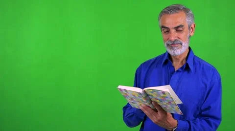 Old senior man reads book - green screen - studio Stock Footage