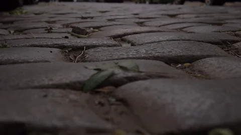 Old sett paved road at Rome, closer, headlight reflection at polished blocks Stock Footage