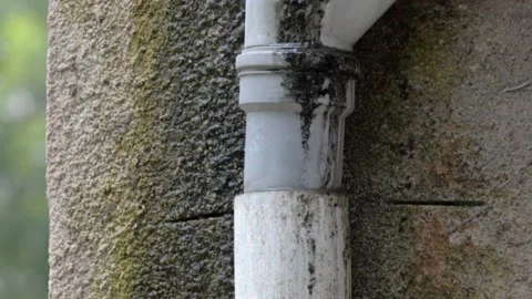 An old sewer pipe on a wall of a residential building leaks Video stock 134326316