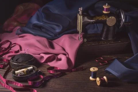 Old sewing machine, fabrics, scissors and other accessories Stock Photos