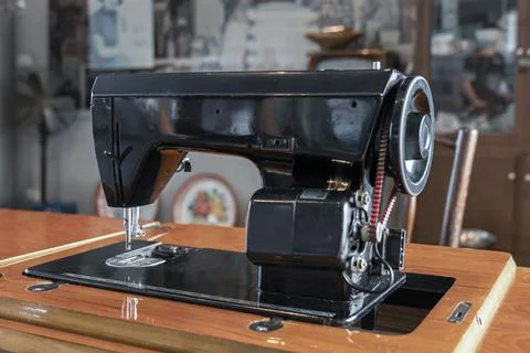 Old sewing machine in a retro interior close-up Stock Photos