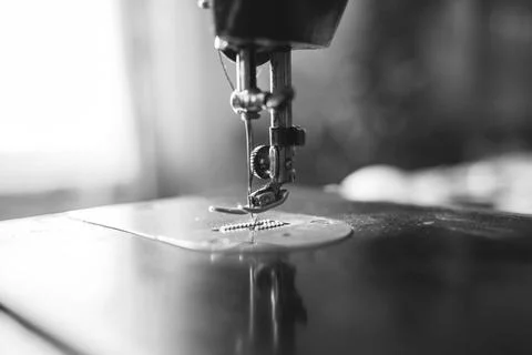 Old sewing machine stands on the table at home ready to work and sew. Stock Photos