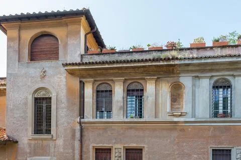 Old shabby plaster facade with a window renaissance ornament and metal bars Stock Photos