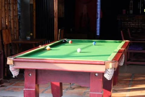 An old, shabby pool table. White ball in the center of the pool table. Foto stock