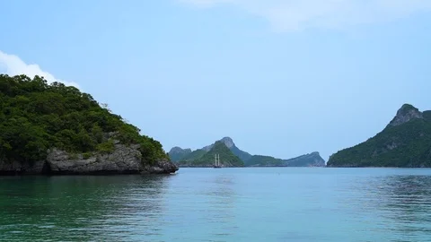 Old ship with masts sailing among tropical islands Stock Footage 117297158