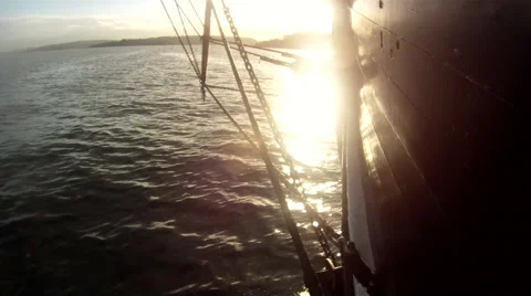 Old Ship moving through water at sunset Video stock 64638812