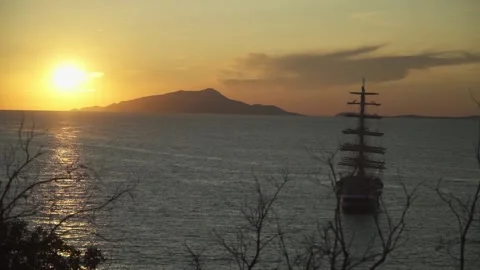 Old Ship on Sea at Sunset Dusk Clouds on Sky Island in Horizon Stock Footage 139717928