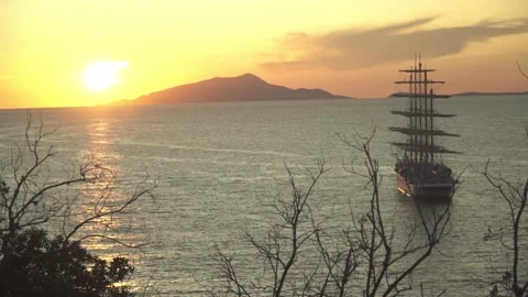 Old Ship on Sea at Sunset Dusk Clouds on Sky Island in Horizon Stock Footage 139717980
