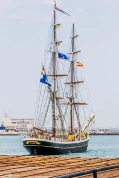 Old ship with two masts with the sails picked up leaving the port Stock Photos