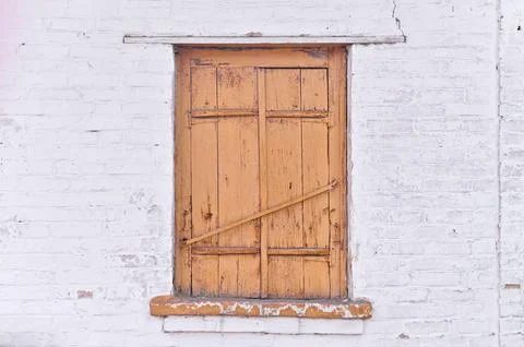 The old shutters on the window are closed Stock Photos