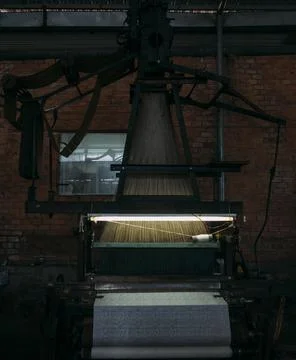 Old silk weaving machine running, creating new silk cloth. Stock Photos