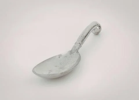 Old silver spoon with curved handle Photos