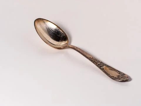 Old silver tea spoon lies on a white background Stock Photos