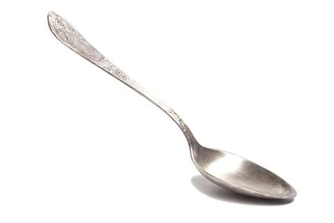 Old silver teaspoon with handle pattern isolated on white background Photos
