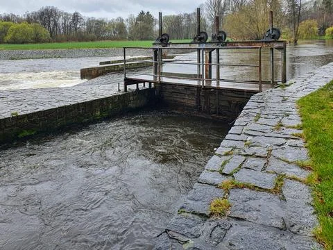 An old simple sluice gate to divert the mill stream from the river bed Stock Photos