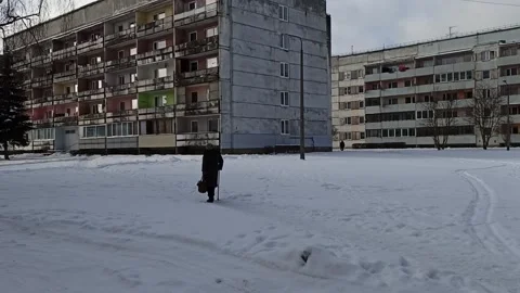 Old slow lady walking in the snow in Latvia outside Stock Footage 147949342