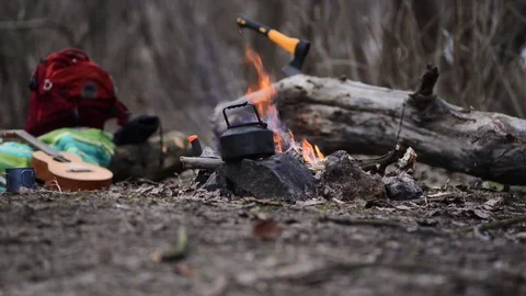 Old small kettle is heated next to a bonfire Stock Footage 95770202