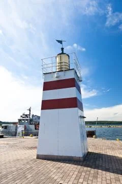 An old small lighthouse on a dock Stock Photos