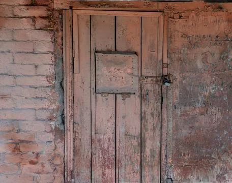 Old small rusty basement door with lock low entrance metal surface urban deta 스톡 사진