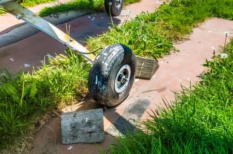 Old small single engine airplane wheel and wooden chocks on parking pad. Stock Photos