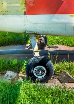 Old small single engine airplane wheels and wooden chocks on parking pad. Foto stock