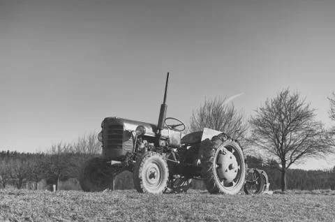 Old small tractor on the field. Stock Photos